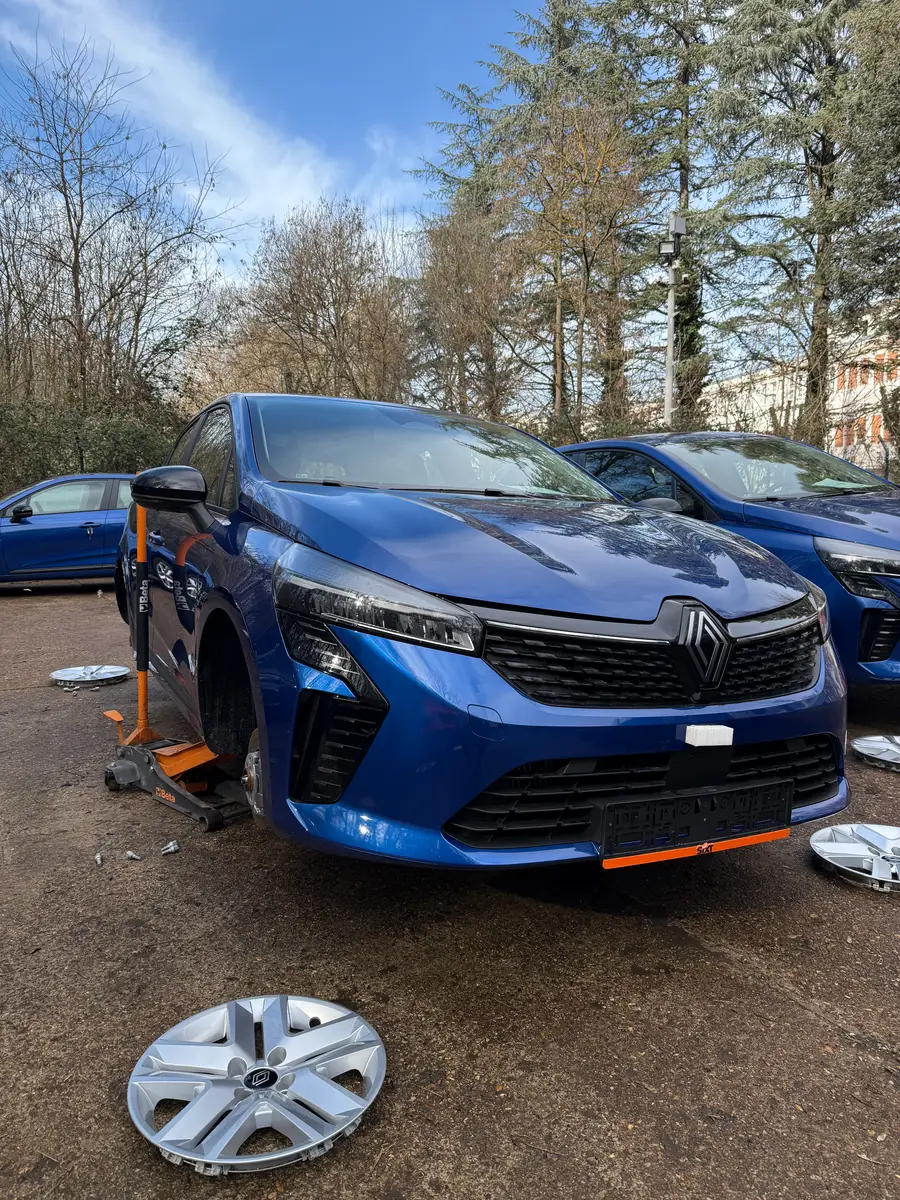 Renault podignut dizalicom tokom zamene gume na parkingu
